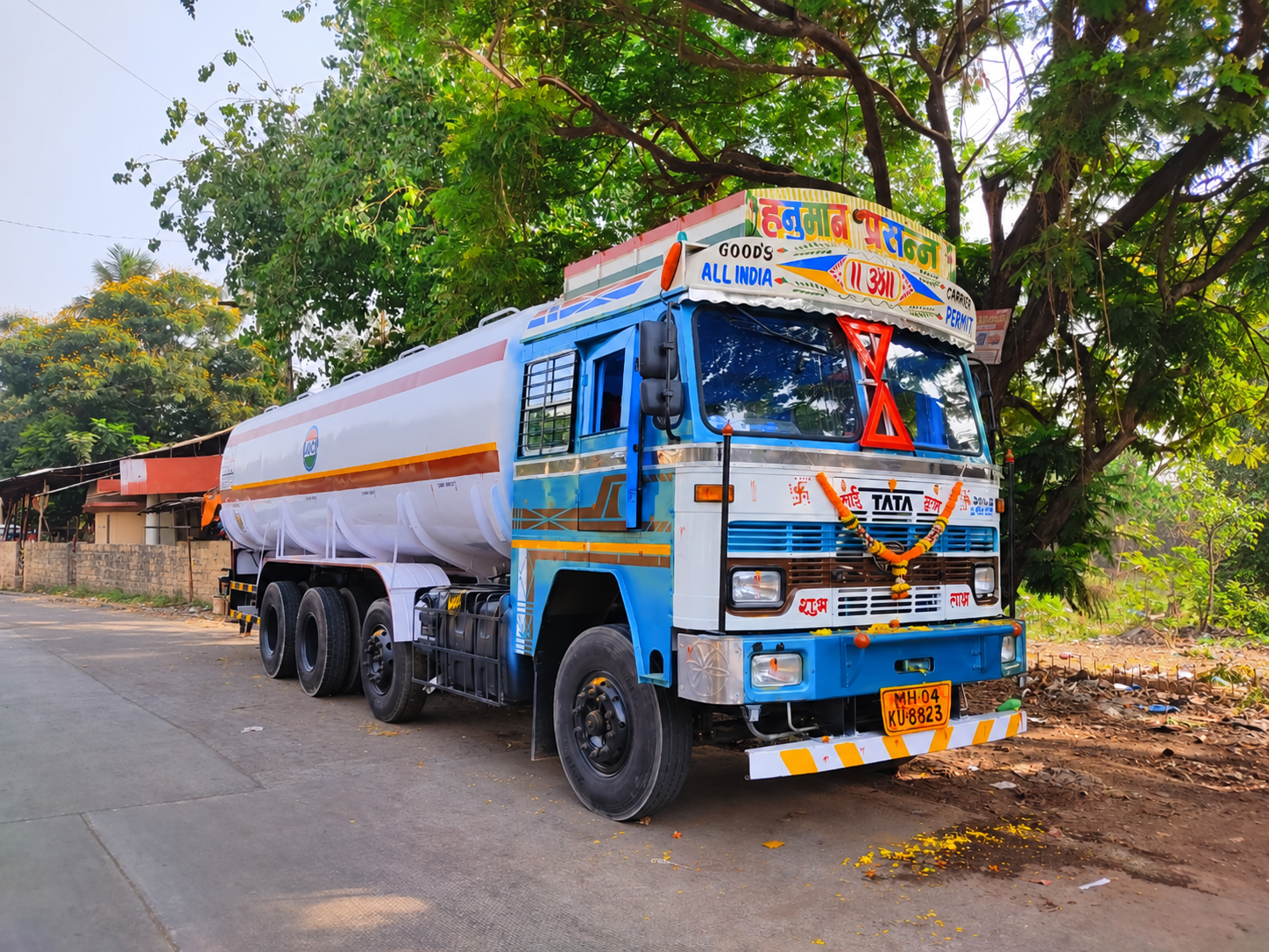 Front and side view of a blue-and-white Tata liquid tanker beside the road